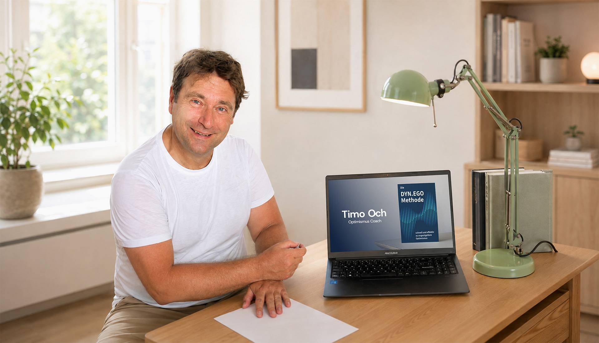 Timo Och sitzt im hellen Arbeitszimmer am Schreibtisch mit Laptop zur DYN.EGO Methode.